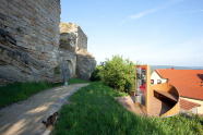 Burgruine Altenstein – links hochaufragende Mauerreste, davor verläuft Weg, ab Wegscheitel rechst Dächer von Häusern des Dorfes