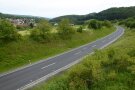 In einem leichten Bogen zieht sich eine Straße durch die Rhöner Hügellandschaft. Das ist die Ortsumgehung von Oberweißenbrunn.
