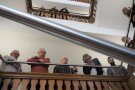 Über die Brüstungen im Treppenhaus blicken viele Personen. Sie verfolgen die Eröffnung der neuen Dauerausstellung im Hauptgebäude des ALE Unterfranken.