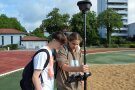 Zwei Schüler suchen Orientierungspunkte mittels eines professionellen Satellitenempfangsgeräts.