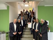 Mehrere Personen sind für ein Gruppenbild aufgestellt.