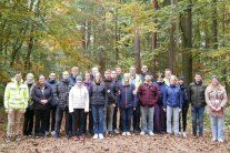 Gruppenfoto mit über 20 jungen Leuten auf einer Waldlichtung.
