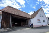 ALE-Leiter Jürgen Eisentraut und Oberthulbas Bürgermeister Mario Götz stehen vor einem zu sanierten Gebäude in Wittershausen.