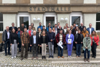 Gut drei Dutzend fröhliche Menschen haben sich vor dem Eingang der Stadthalle in Eltmann zu einem Gruppenfoto aufgereiht.