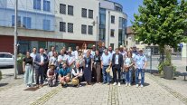 Gruppenbild mit mehreren Personen vor einem Rathaus.