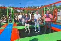 Auf einem Trampolin eröffnen mehrere Personen symbolisch eine Trampolinanlage.