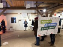 In einer Kulturscheune sind Menschen bei einem Vortrag zu sehen.