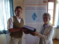 Der Forstsachverständige und Helfer im Freiwilligen Landtausch Neuendorf Paul Gerlach übergibt der Projektleiterin Eva Kiesekamp die Tauschvereinbarungen.