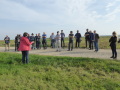 Während einer Wanderung konnten sich die Bürger ein Bild von den umgesetzten Projekten machen. Miriam Glanz vom gleichnamigen Planungsbüro steht auf einem Grünstreifen vor der Teilnehmergruppe und erläutert die landschaftspflegerischen Maßnahmen in der Flurneuordnung Hendungen