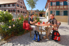 Zwei Wanderer trinken im Dorf Kaffee und sitzen im Freien